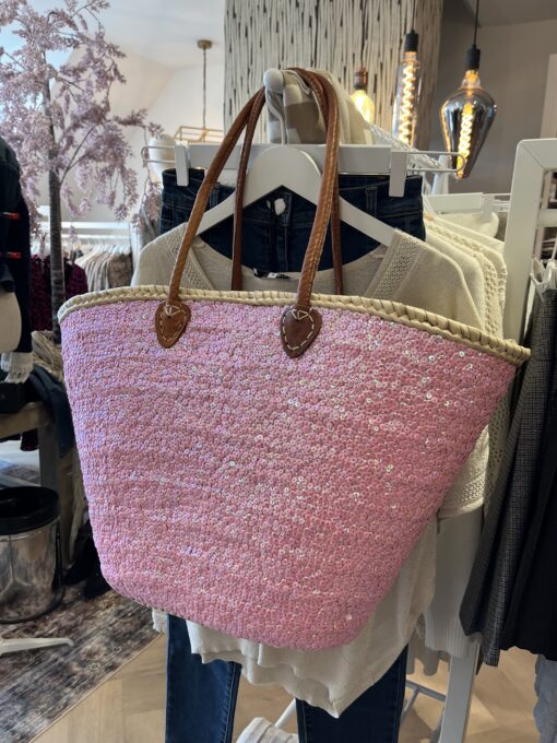rieten strandtas boho roze 39,95 Super gave rieten strandtas met dichte rietrand en roze pailletten. Onze Westmoodz collectie rieten strandtassen zijn handmade gevlochten tassen… de pailletten zijn er stuk voor stuk opgenaaid waardoor ze stevig vast zitten op het riet. De rieten strandtas is afgewerkt met extra lange leren hengsels, zodat deze makkelijk op de schouders kan worden gedragen. De hengsels zitten vast aan de tas met metalen spikes, waardoor het geen probleem is om lekker veel spullen/gewicht mee te nemen. Dat maakt de tas heel handig en leuk als shopper…maar helemaal geweldig voor een dagje on the beach! De strandtas heeft een afsluitbare binnenvoering met tunnelkoord. Onze rieten strandtassen worden hand gemaakt in Marrakech. Het strandtas op de foto is model boho Model boho heeft een dicht gevlochten rietrand Boho BIG size 40cm hoog – 50cm breed