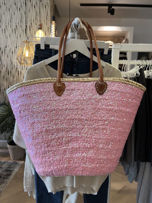 rieten strandtas boho roze 39,95 Super gave rieten strandtas met dichte rietrand en roze pailletten. Onze Westmoodz collectie rieten strandtassen zijn handmade gevlochten tassen… de pailletten zijn er stuk voor stuk opgenaaid waardoor ze stevig vast zitten op het riet. De rieten strandtas is afgewerkt met extra lange leren hengsels, zodat deze makkelijk op de schouders kan worden gedragen. De hengsels zitten vast aan de tas met metalen spikes, waardoor het geen probleem is om lekker veel spullen/gewicht mee te nemen. Dat maakt de tas heel handig en leuk als shopper…maar helemaal geweldig voor een dagje on the beach! De strandtas heeft een afsluitbare binnenvoering met tunnelkoord. Onze rieten strandtassen worden hand gemaakt in Marrakech. Het strandtas op de foto is model boho Model boho heeft een dicht gevlochten rietrand Boho BIG size 40cm hoog – 50cm breed