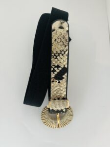 damesriem strech snake print Deze trendy damesriem is een ware blikvanger dankzij de stylishe slangenprint op de voorkant. De riem is uitgerust met een prachtige shiny gesp die een elegante combinatie van goud en zilveren metaaldraad biedt, wat zorgt voor een luxueuze uitstraling. De elastische zwarte band past zich perfect aan en geeft een flatterende uitstraling, vooral in combinatie met een zwarte broek. Hierdoor wordt de aandacht prachtig naar de gesp geleid, wat een chique detail toevoegt aan elke outfit. **Kenmerken:** - *Design:* Slangenprint op de voorkant - *Gesp:* Shiny, met een combinatie van goud en zilveren metaaldraad - *Materiaal:* Elastische zwarte band - *Stijl:* Geschikt voor casual en chique outfits Met deze riem voeg je moeiteloos een statement toe aan je look!