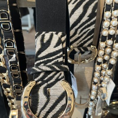 damesriem strech tijger print grijs Deze trendy damesriem is een ware blikvanger dankzij de stylish tijgerprint op de voorkant. De riem is uitgerust met een prachtige shiny gesp die een elegante combinatie van goud, wat zorgt voor een luxueuze uitstraling. De elastische zwarte band past zich perfect aan en geeft een flatterende uitstraling, vooral in combinatie met een zwarte broek. Hierdoor wordt de aandacht prachtig naar de gesp geleid, wat een chique detail toevoegt aan elke outfit. **Kenmerken:** - *Design:* tijgerprint grijs op de voorkant - *Gesp:* Shiny, met een combinatie van goud - *Stijl:* Geschikt voor casual en chique outfits Met deze riem voeg je moeiteloos een statement toe aan je look!