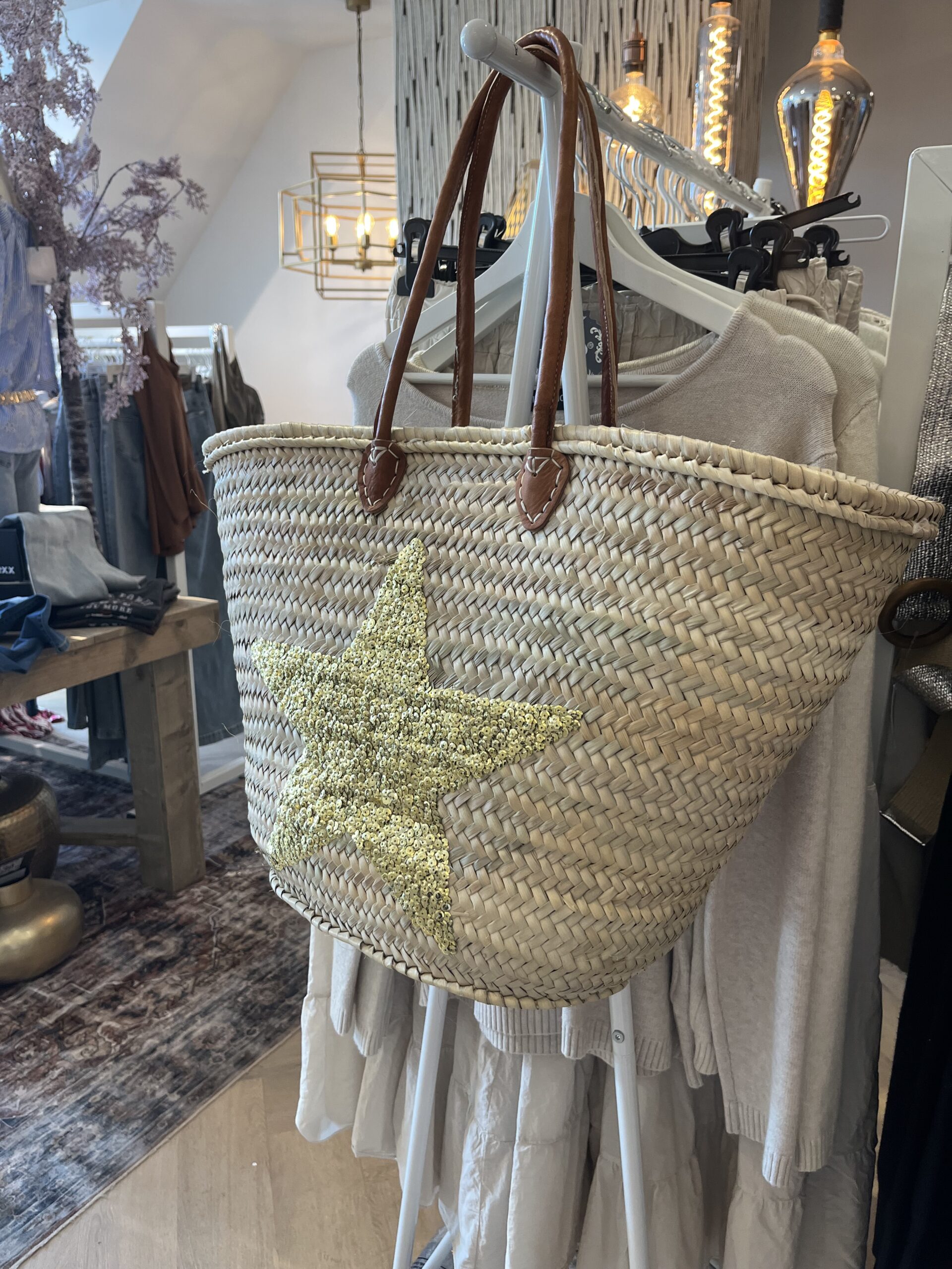rieten strandtas ster goud 29.95 Super gave rieten strandtas met dichte rietrand en gouden pailletten ster Onze Westmoodz collectie rieten strandtassen zijn handmade gevlochten tassen… de pailletten zijn er stuk voor stuk opgenaaid waardoor ze stevig vast zitten op het riet. De rieten strandtas is afgewerkt met extra lange leren hengsels, zodat deze makkelijk op de schouders kan worden gedragen. De hengsels zitten vast aan de tas met metalen spikes, waardoor het geen probleem is om lekker veel spullen/gewicht mee te nemen. Dat maakt de tas heel handig en leuk als shopper…maar helemaal geweldig voor een dagje on the beach! De strandtas heeft een afsluitbare binnenvoering met tunnelkoord. Onze rieten strandtassen worden hand gemaakt in Marrakech.