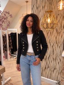 Zwart jasje dubbel knoop met stoere bikerlook en luxe goudkleurige details. De dubbele knopenrij, schuine ritssluiting en vrouwelijke pasvorm maken dit zwarte damesjasje perfect voor zowel een casual als geklede outfit.